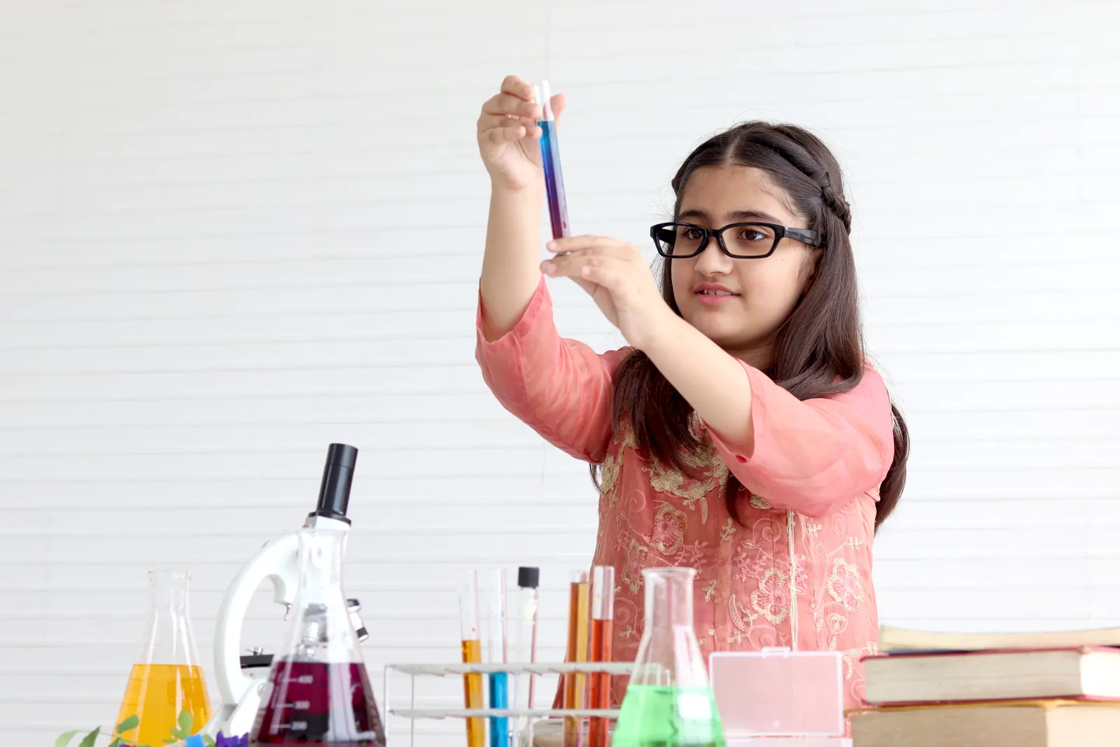 A schoolgirl holds a chemistry test tube
