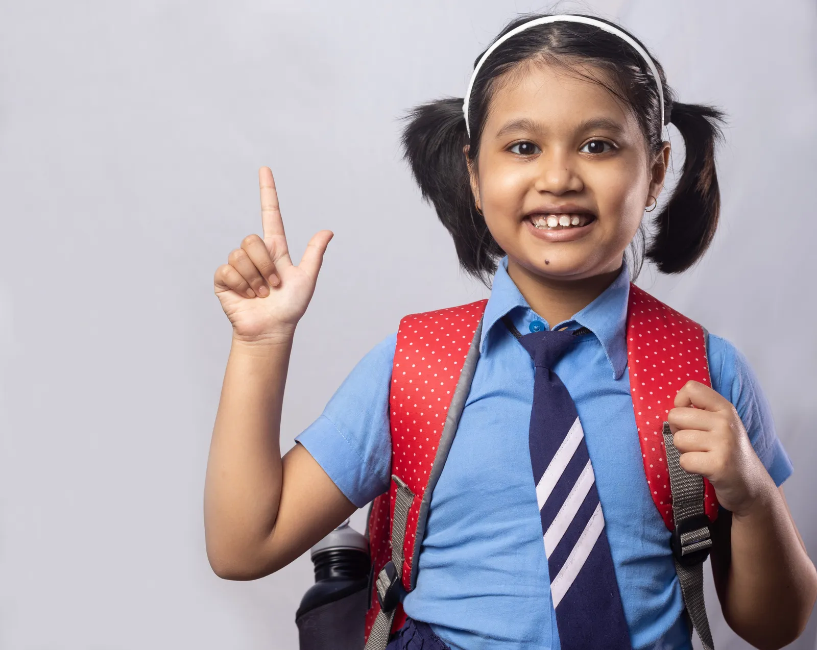 A schoolgirl in uniform points upward