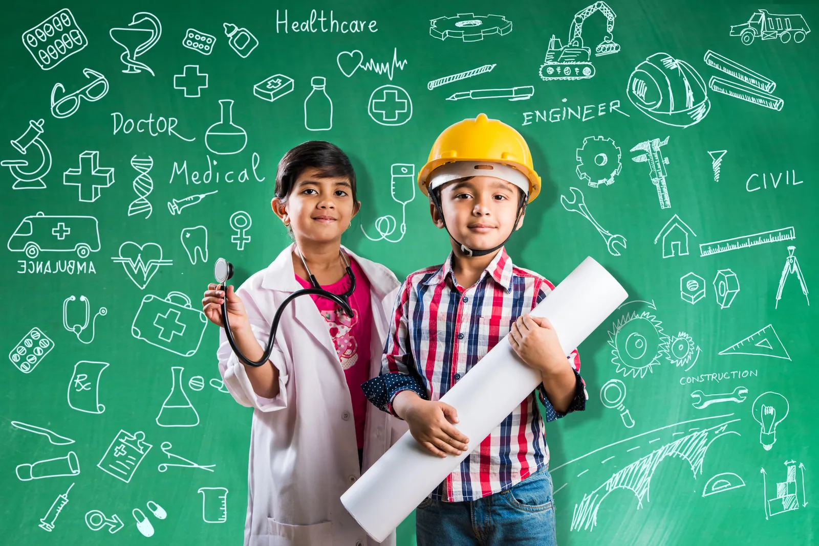 Children dressed as a doctor, an engineer, and a student stand in front of a classroom chalkboard